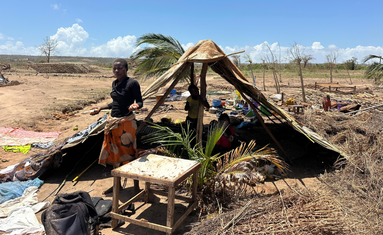 Una mujer de pie frente a un refugio improvisado