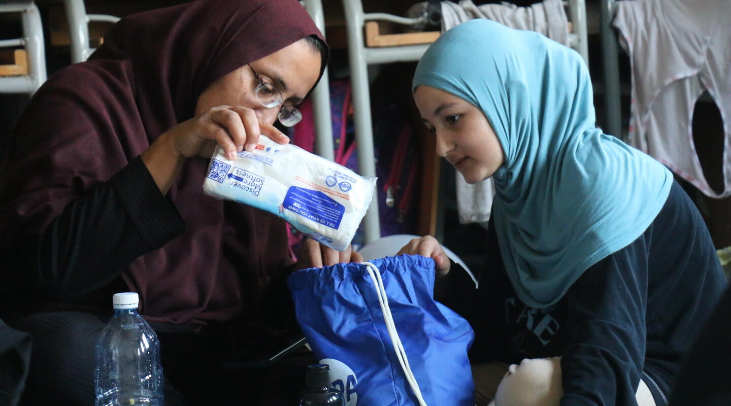 Una madre y una hija reciben kits de higiene en una escuela que sirve de refugio en el Líbano.